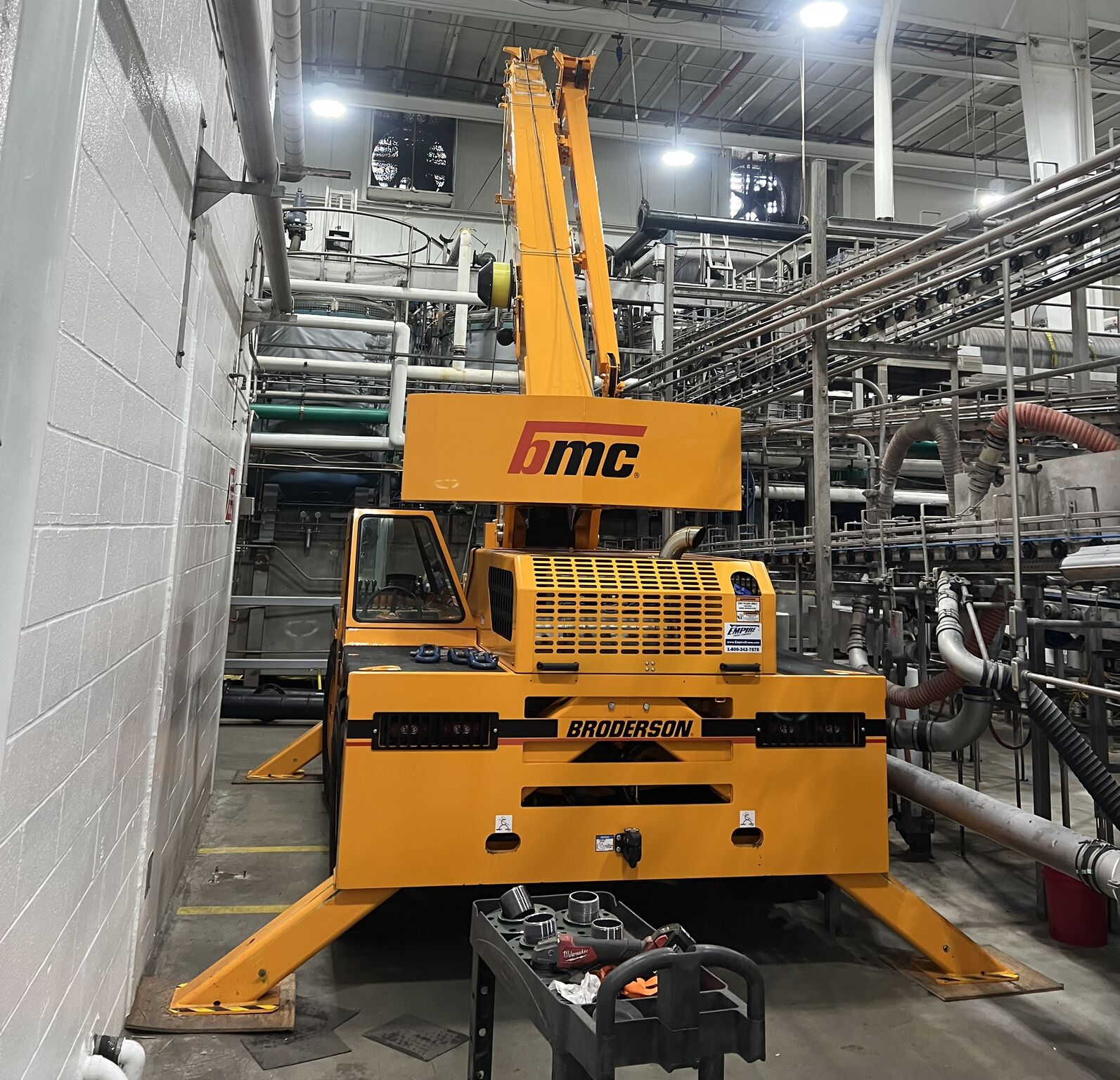 A crane lifting a very large metal LP tank