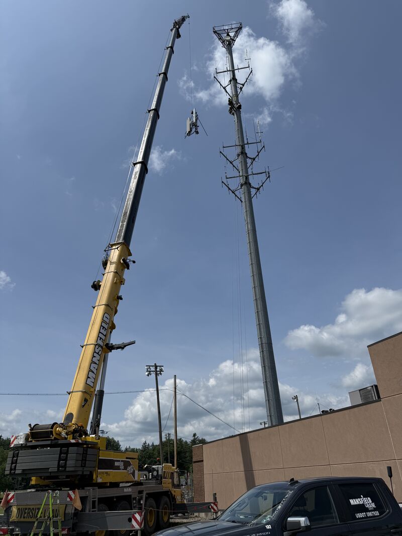 A crane lifting a very large metal LP tank